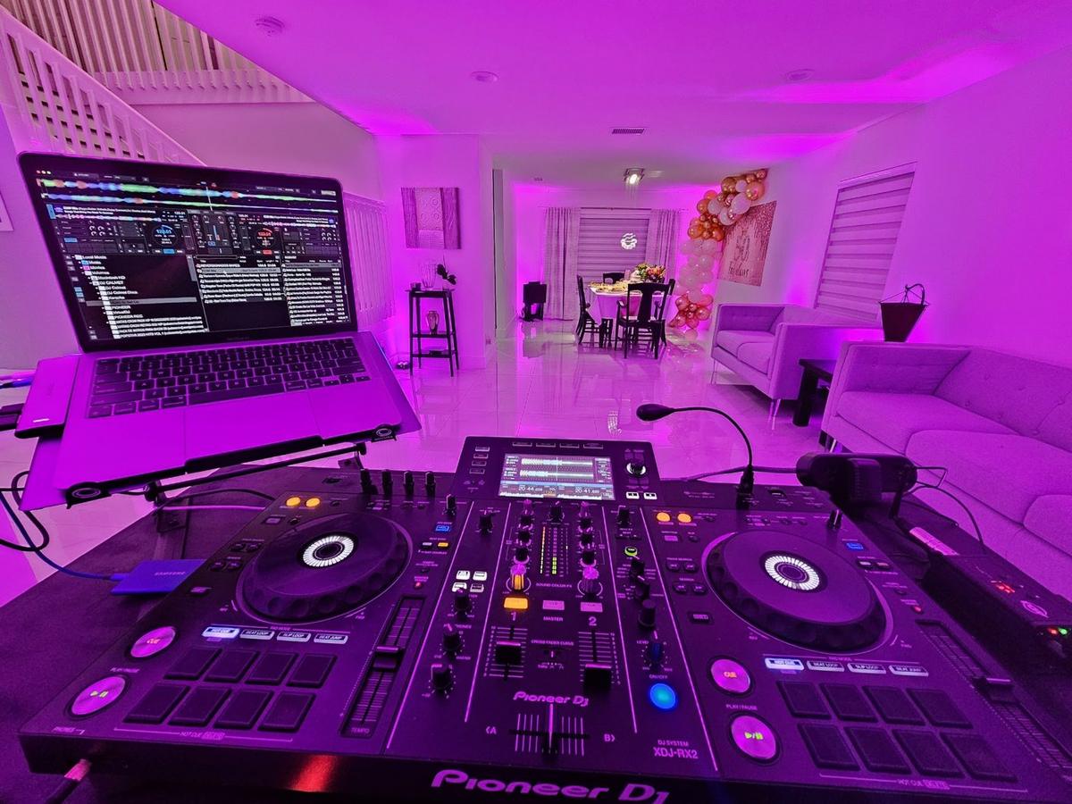 Equipo de DJ Calmet con luces moradas en una fiesta