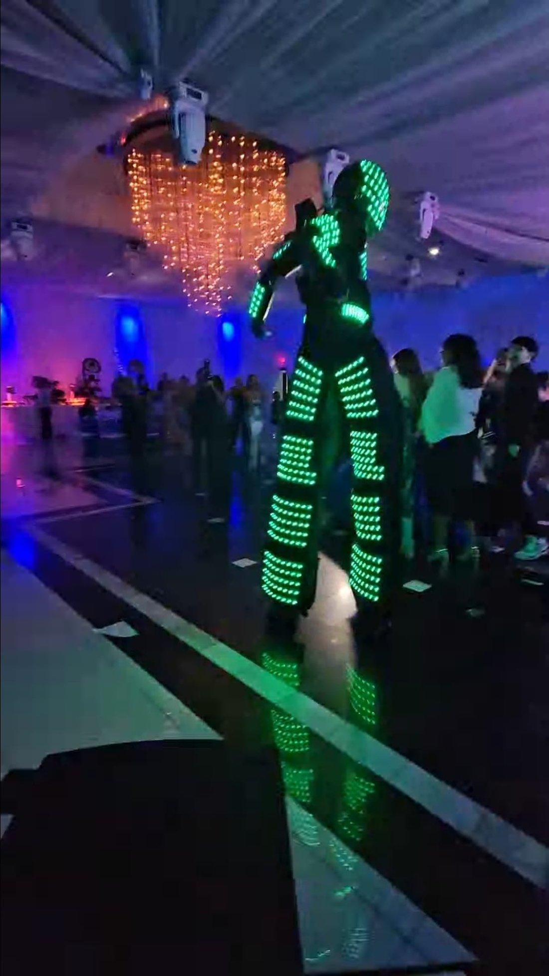 Robot LED en zancos en la pista